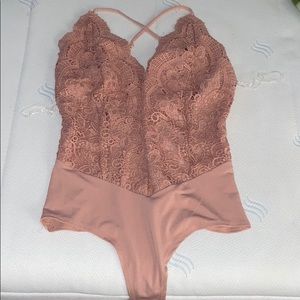 Nude pink bodysuit with detailing.